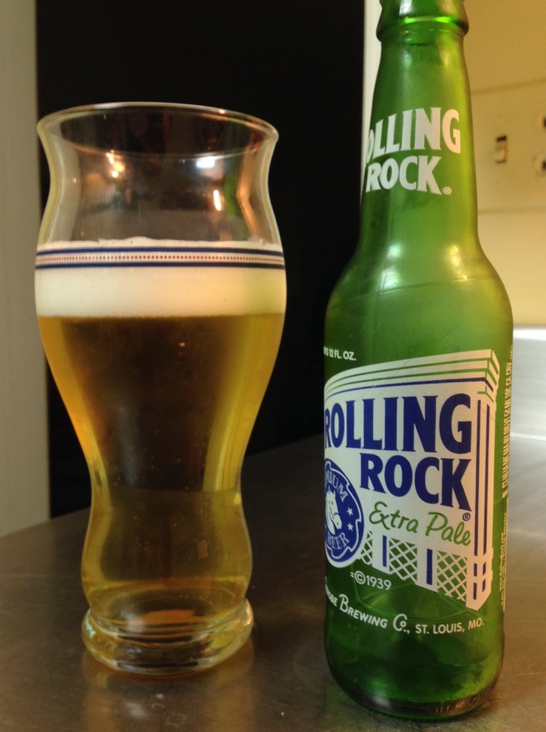 Rolling Rock Extra Pale, Anheuser‑Busch InBev. American adjunct lager, 4.5 percent alcohol by volume. I was a regular Rolling Rock drinker for a year or two way back in the day, well before the brand was purchased by A-B and production was moved to the glass-lined tanks of old New Jersey. And here's the interesting thing: Rolling Rock is actually better now than I remember. Rolling Rock didn't have the same sweetness as many of the other beers I regularly grabbed in those days; in fact, it the green bottles gave up enough to the sun that it wasn't unusual to some across some skunky flavors pretty consistently. Now? No skunky, but also no cloying sweet like its counterparts. 